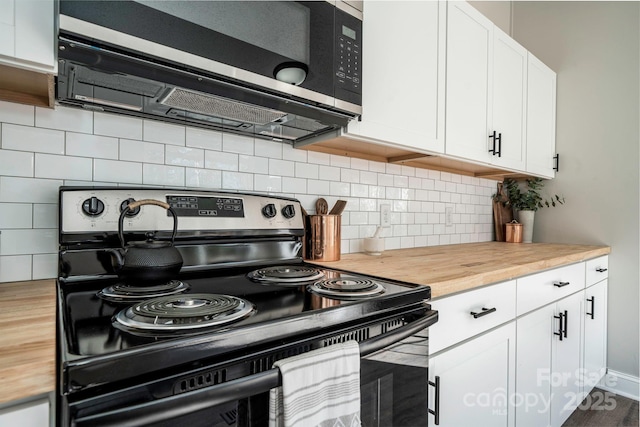 kitchen featuring white cabinets, butcher block counters, stainless steel appliances, and tasteful backsplash