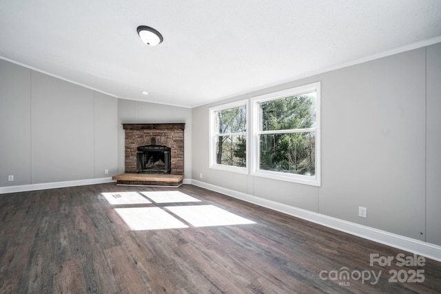 unfurnished living room with dark hardwood / wood-style flooring, ornamental molding, a fireplace, and vaulted ceiling