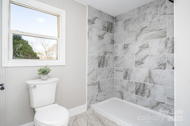 bathroom featuring a shower and toilet