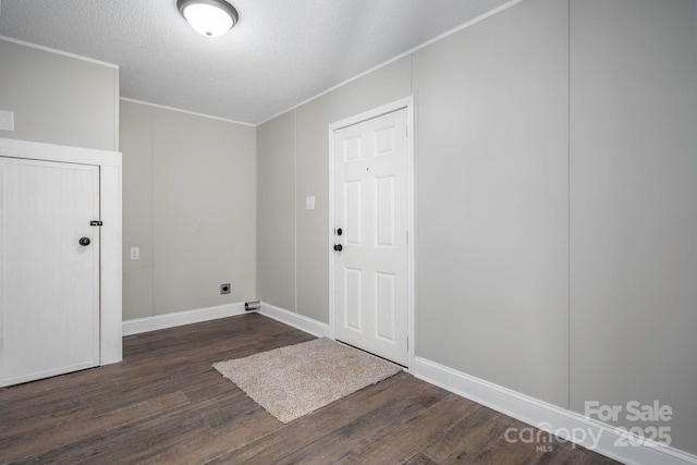 laundry area with hookup for an electric dryer, dark hardwood / wood-style flooring, and a textured ceiling