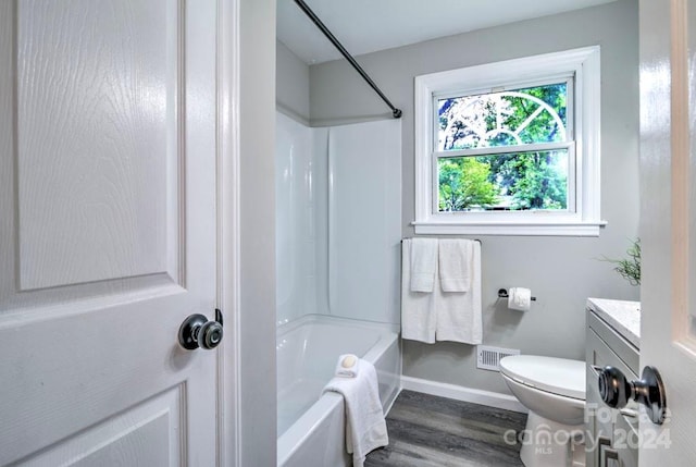 full bathroom with vanity, toilet, hardwood / wood-style floors, and shower / tub combination