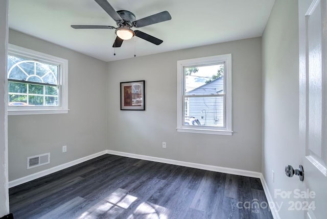 empty room with ceiling fan and dark hardwood / wood-style flooring