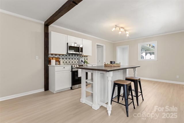 kitchen featuring white cabinetry, tasteful backsplash, stainless steel appliances, and a kitchen island