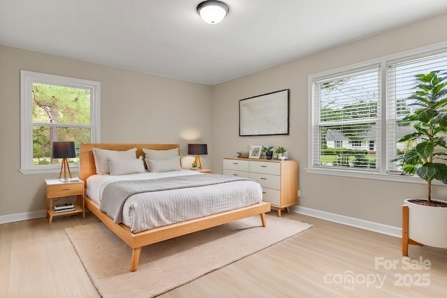 bedroom featuring multiple windows and light wood-type flooring