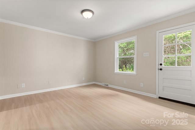 unfurnished room with crown molding, a healthy amount of sunlight, and light hardwood / wood-style floors