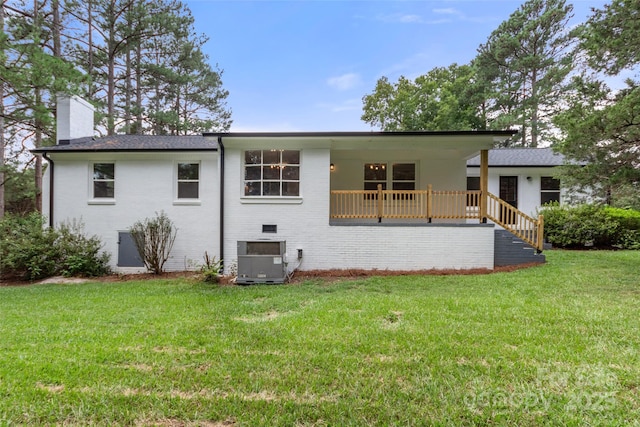 back of property with central AC unit, a yard, and a wooden deck