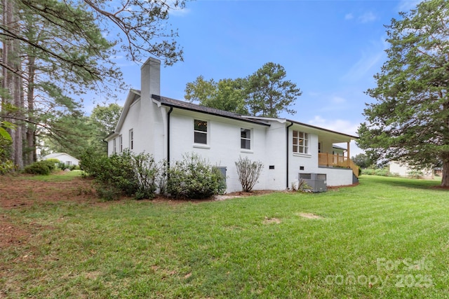 back of house with central AC and a lawn