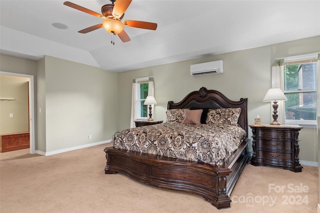 carpeted bedroom with lofted ceiling, ceiling fan, an AC wall unit, and ensuite bathroom