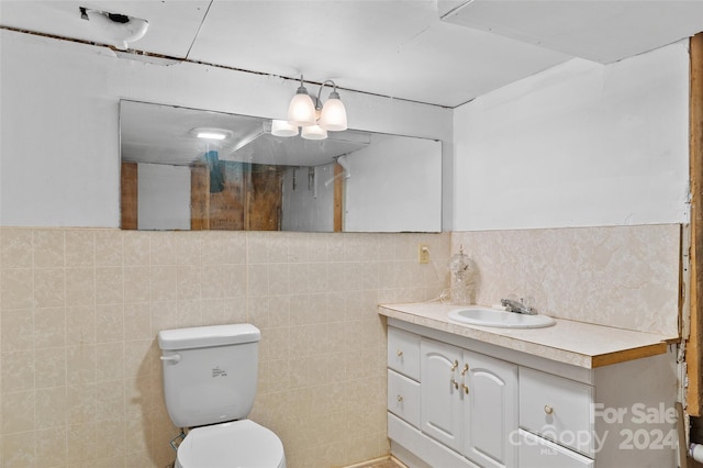 bathroom featuring vanity, toilet, tile walls, and decorative backsplash