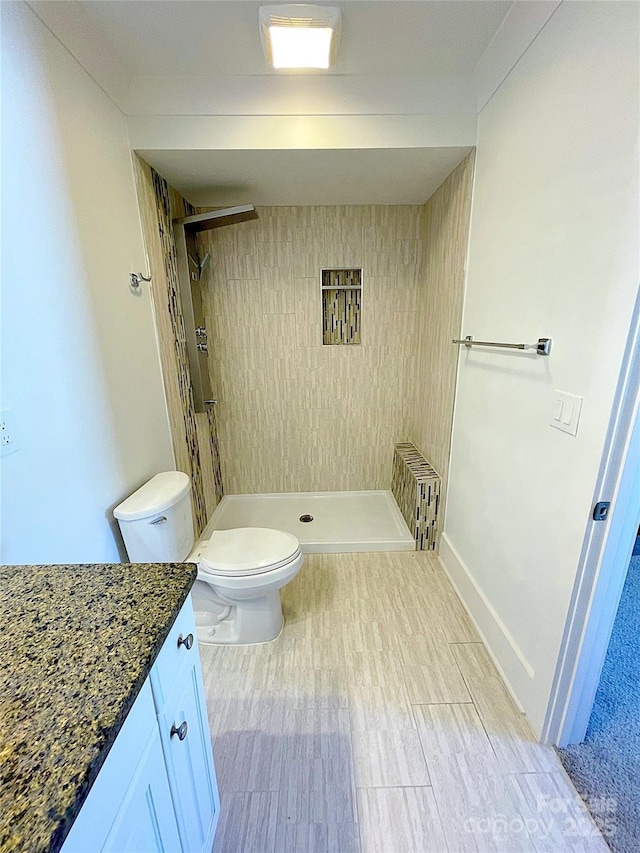 bathroom featuring vanity, toilet, and walk in shower