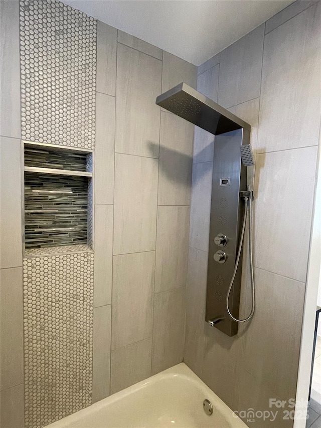 bathroom featuring tiled shower / bath