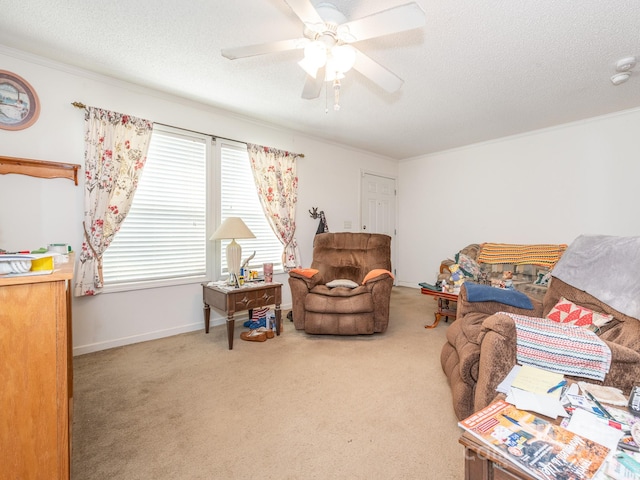 living room featuring ceiling fan, ornamental molding, a textured ceiling, and carpet flooring