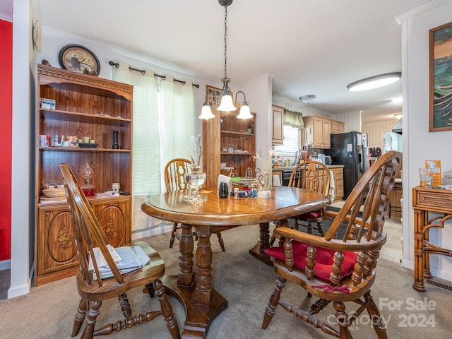 carpeted dining room featuring a notable chandelier, crown molding, and a textured ceiling