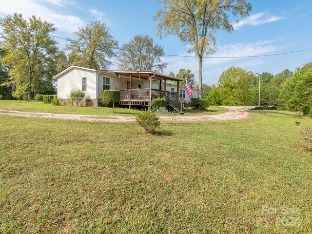 view of front of property featuring a front lawn and a wooden deck