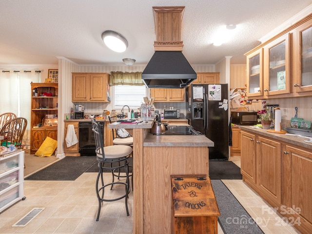 kitchen with a textured ceiling, a kitchen island, a kitchen breakfast bar, black appliances, and ornamental molding