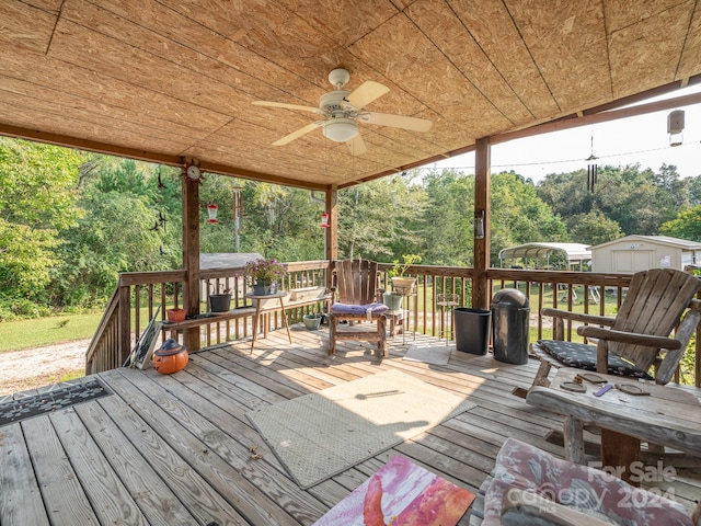 wooden deck with ceiling fan and a storage shed