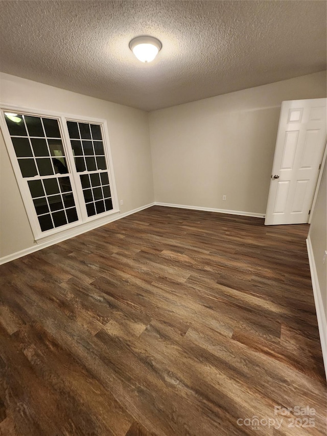 empty room featuring dark hardwood / wood-style flooring and a textured ceiling