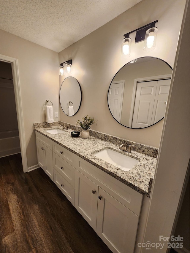 bathroom featuring vanity, hardwood / wood-style flooring, and a textured ceiling