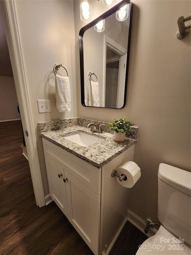 bathroom with vanity, hardwood / wood-style floors, and toilet