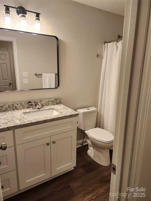 bathroom with hardwood / wood-style flooring, vanity, and toilet