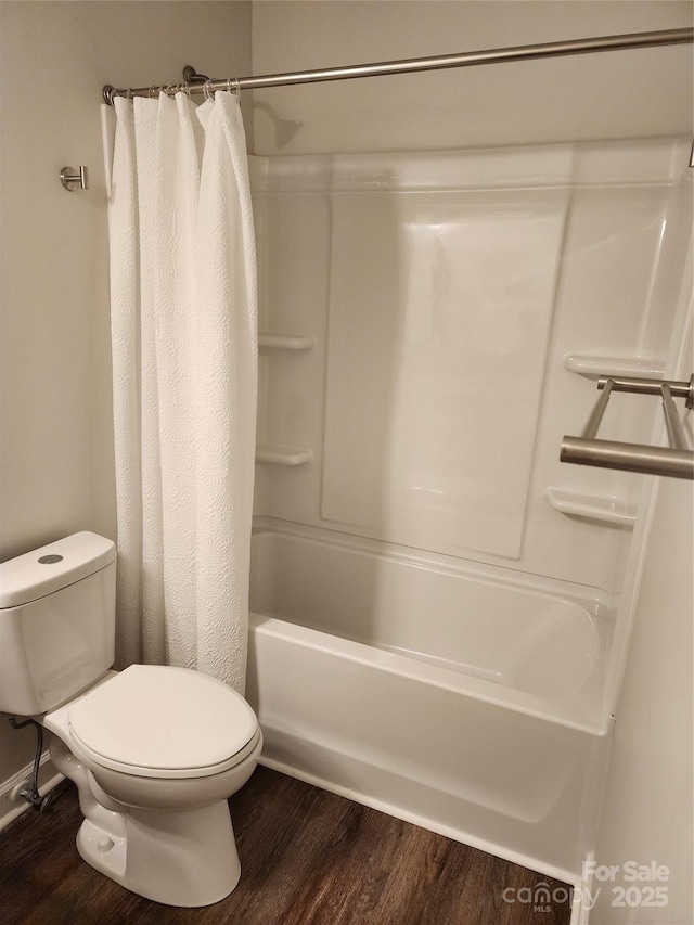 bathroom featuring hardwood / wood-style floors, toilet, and shower / bath combo with shower curtain