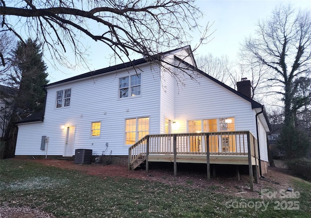 back of house with a wooden deck, a lawn, and central air condition unit