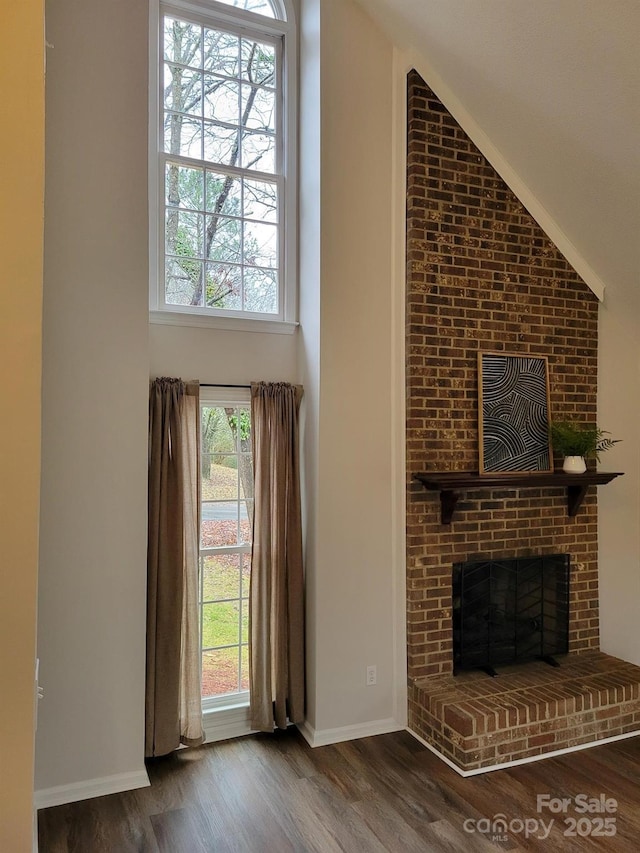 unfurnished living room featuring dark hardwood / wood-style flooring, high vaulted ceiling, and a fireplace