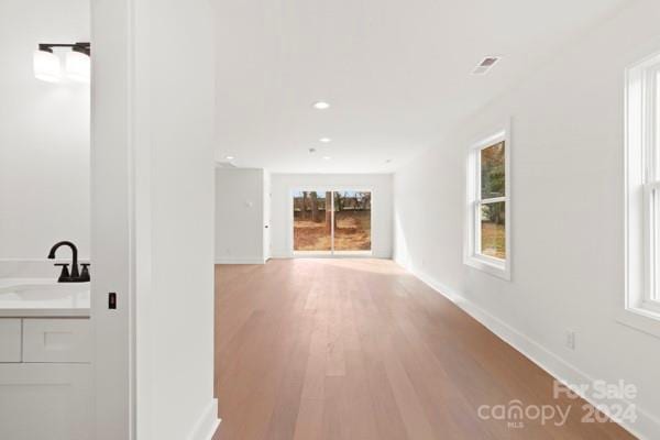 corridor with sink and hardwood / wood-style flooring