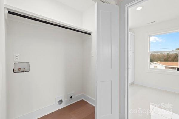 clothes washing area with hardwood / wood-style flooring, hookup for an electric dryer, and hookup for a washing machine