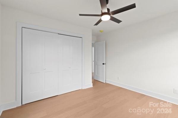 unfurnished bedroom with light wood-type flooring, a closet, and ceiling fan