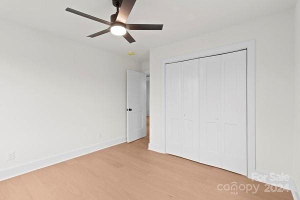 unfurnished bedroom featuring light wood-type flooring, a closet, and ceiling fan