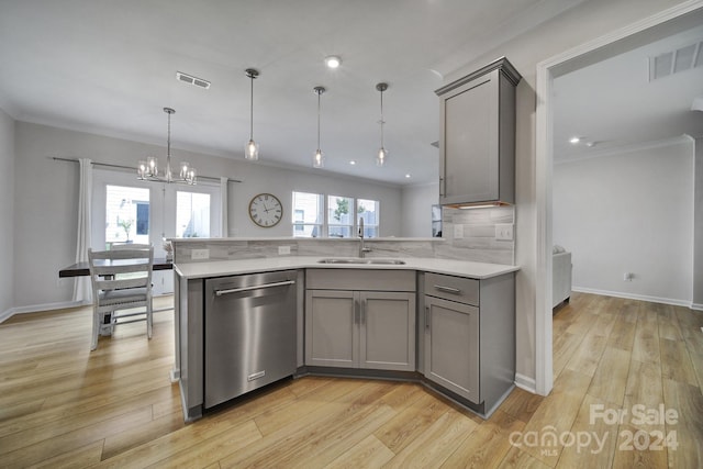 kitchen featuring pendant lighting, crown molding, dishwasher, sink, and light hardwood / wood-style floors