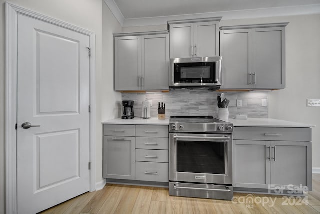 kitchen featuring light wood-type flooring, gray cabinets, and stainless steel appliances