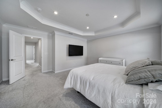 carpeted bedroom featuring a tray ceiling and ornamental molding