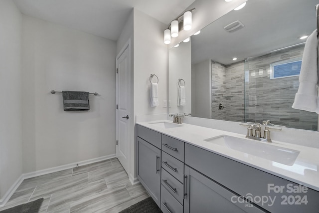 bathroom with tiled shower and vanity