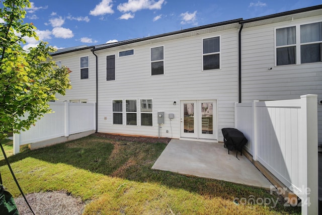 rear view of house with a lawn and a patio