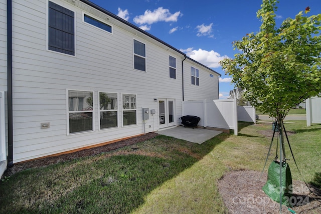 rear view of house featuring a yard and a patio