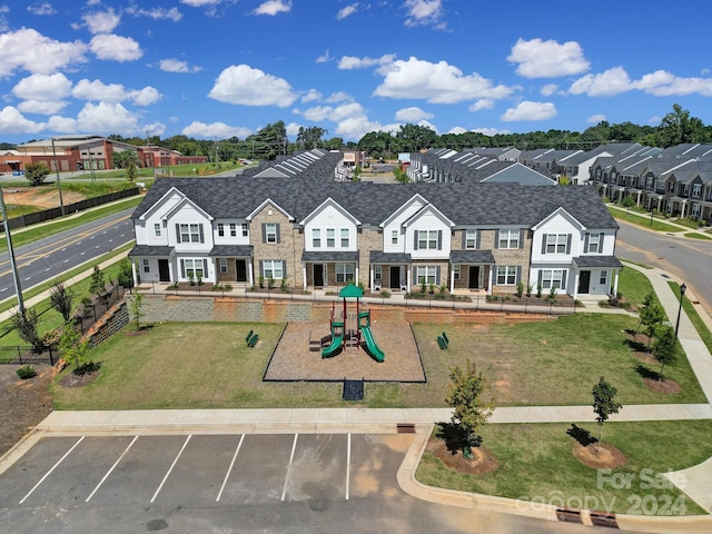 view of front of home with a front lawn and a playground