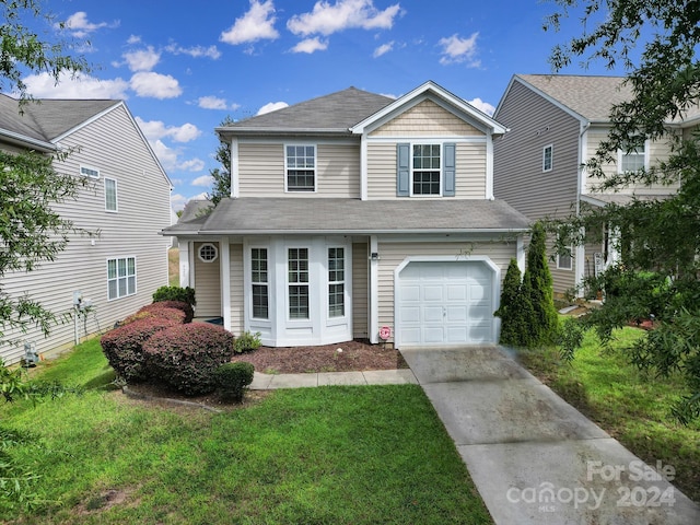 front of property featuring a front yard and a garage