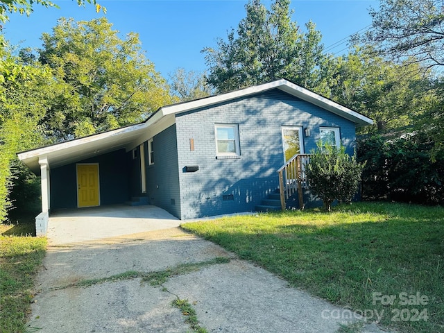 view of front of property with a carport and a front yard