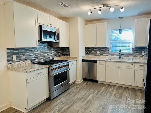 kitchen with light wood-type flooring, appliances with stainless steel finishes, and sink