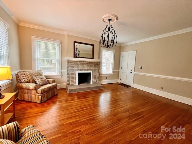 unfurnished living room with a notable chandelier, hardwood / wood-style flooring, a fireplace, and crown molding