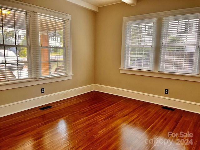 unfurnished room with a wealth of natural light and hardwood / wood-style flooring