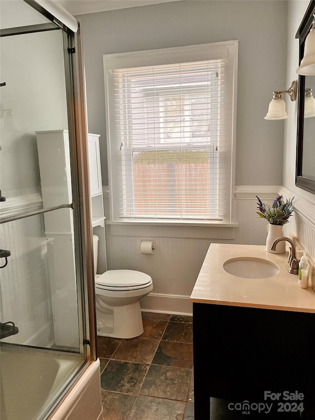 full bathroom featuring vanity, toilet, and combined bath / shower with glass door