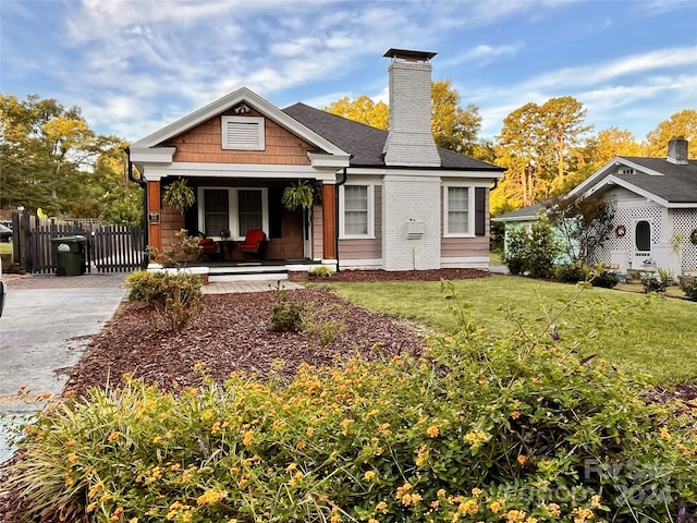 view of front of property with covered porch and a front lawn