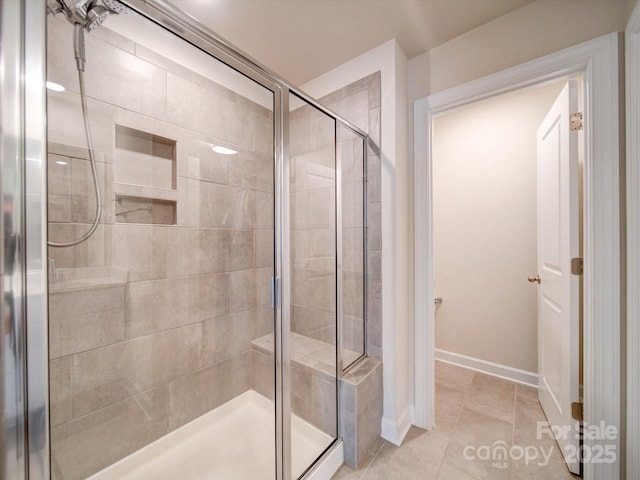 bathroom featuring a shower with shower door and tile patterned floors