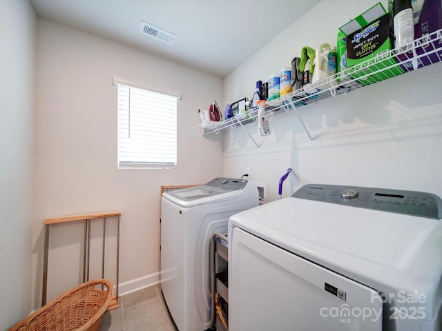 washroom featuring washing machine and dryer and light tile patterned floors