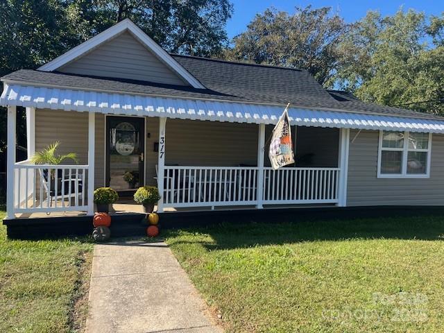 view of front of property with covered porch and a front lawn