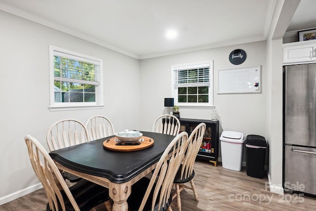 dining room with crown molding and light wood-type flooring