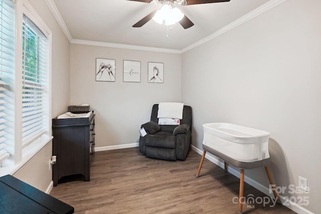 sitting room featuring crown molding, wood-type flooring, and ceiling fan